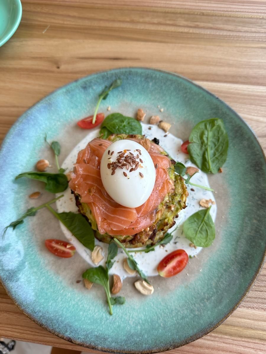 Gourmet avocado toast topped with smoked salmon, poached egg, and fresh greens.