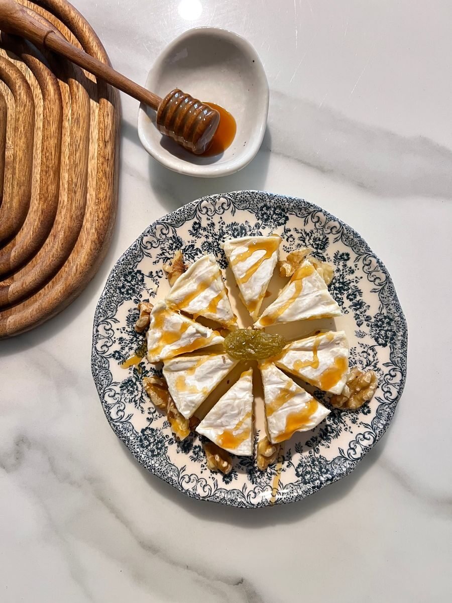 Tasty dessert topped with yogurt and honey drizzle, elegantly served on a vintage plate.