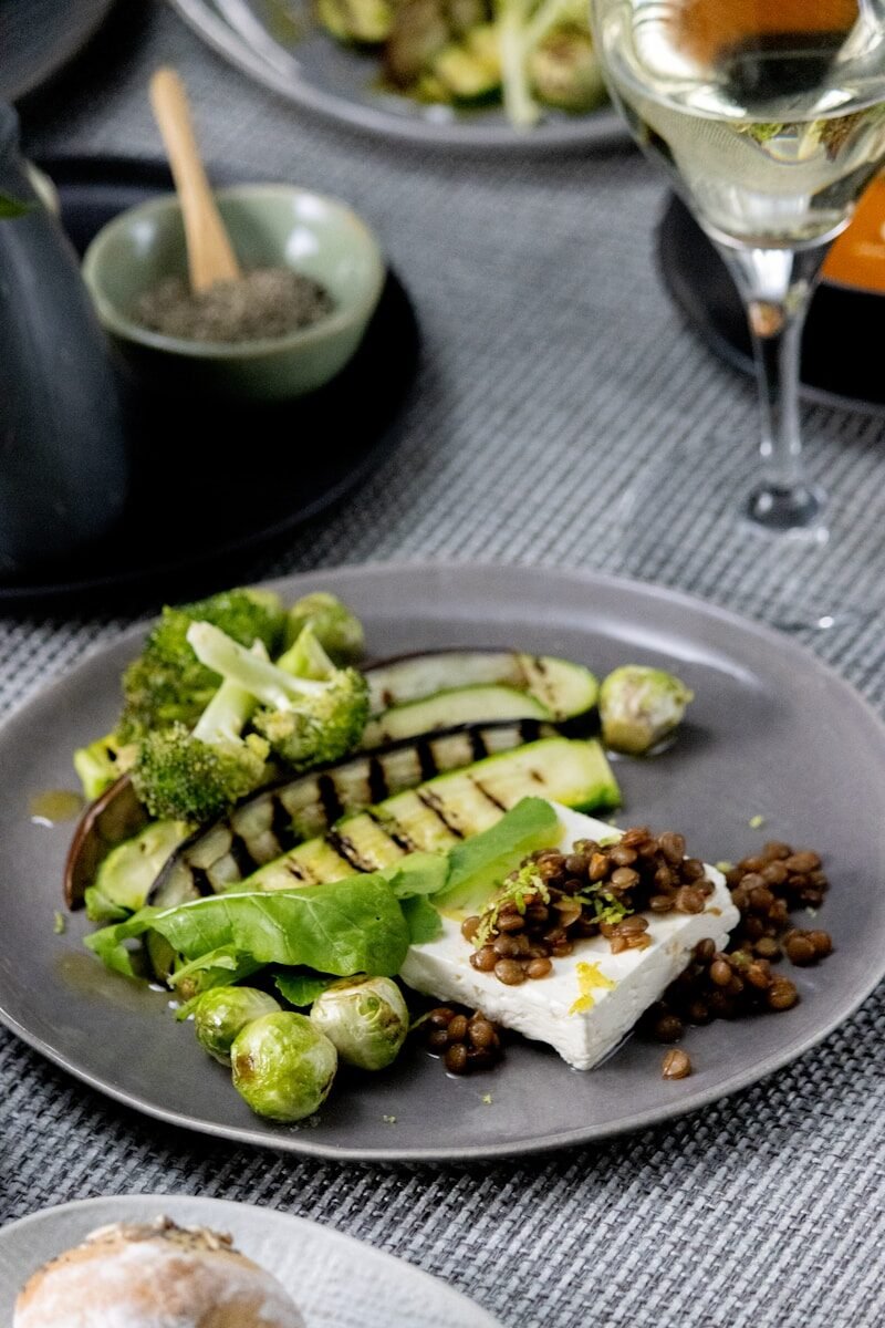a plate of food on a table with a glass of wine