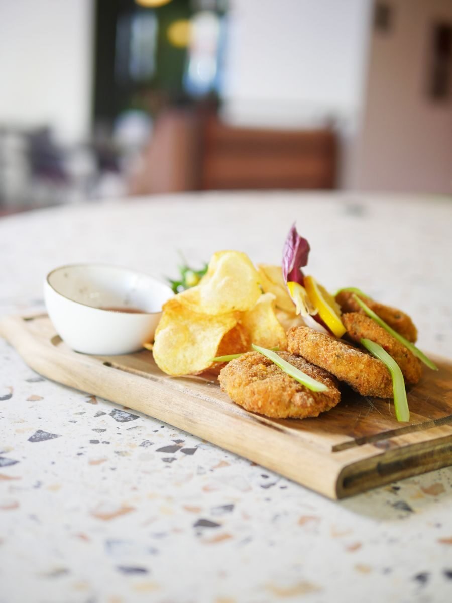 Appetizing snack platter featuring crispy nuggets and chips served with dip, perfect for parties.