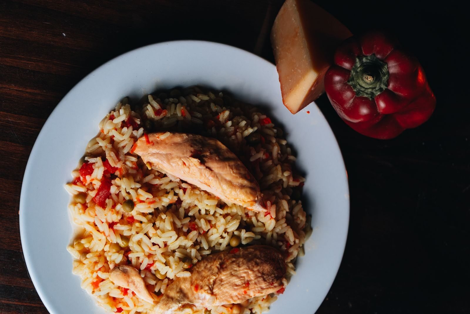 A top view of a chicken and rice dish with red pepper, perfect for food photography.